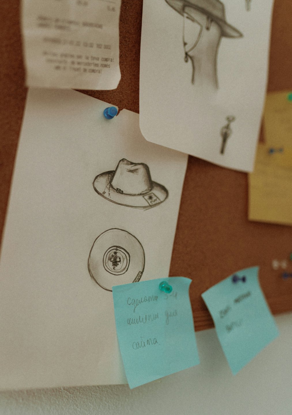 Bacheca di sughero con schizzi, ricevute e post-it.